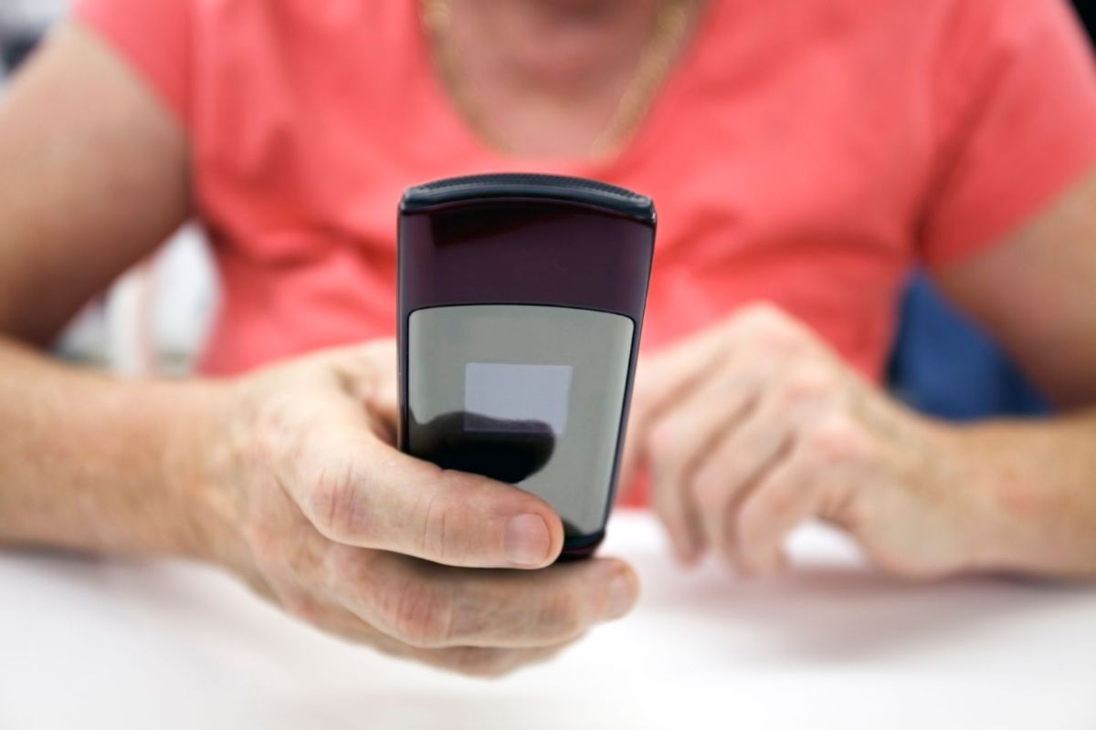 A woman holds a flip phone in front of her