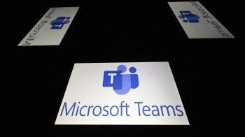 Microsoft Teams logo displayed on screens in a dark setting.