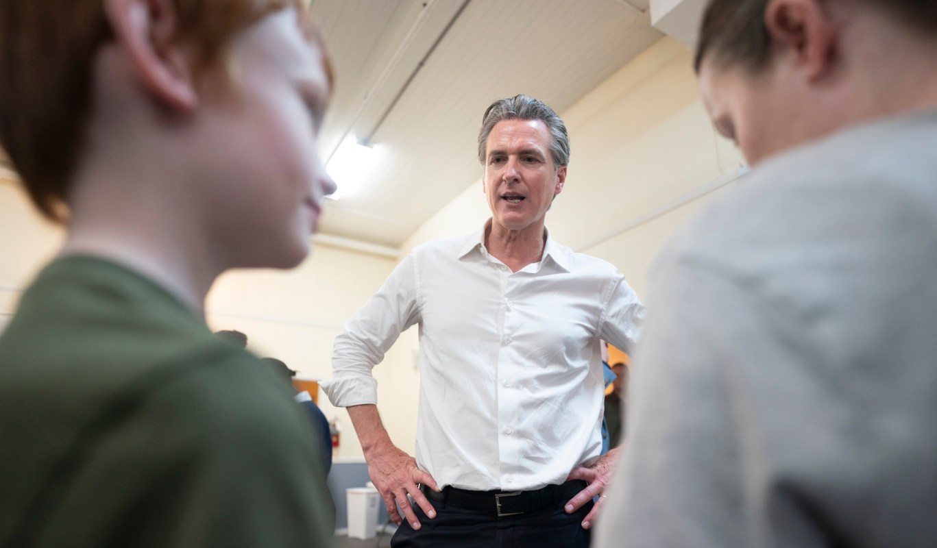 California Gov. Gavin Newsom talks with two young boys.