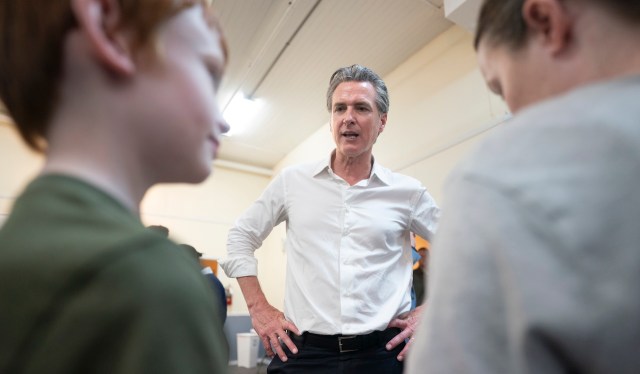 California Gov. Gavin Newsom talks with two young boys.