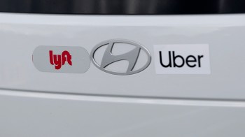 Logos for Lyft, Uber, and Hyundai on a white car's rear panel.