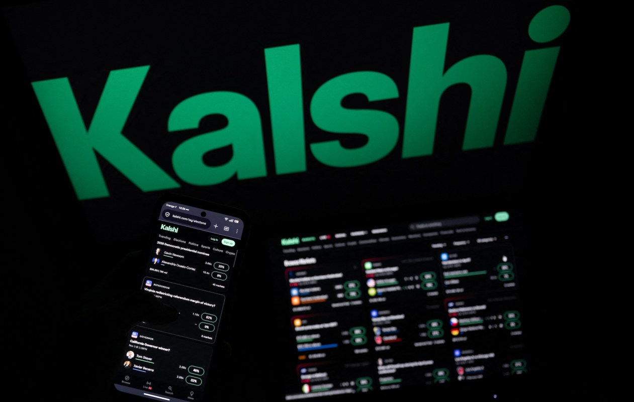 A smartphone displays a Kalshi app interface next to a laptop with a Kalshi trading dashboard.