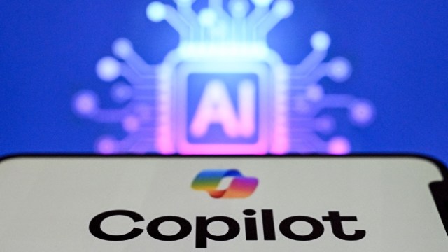 A smartphone displaying the word "Copilot" with an abstract AI circuit background.