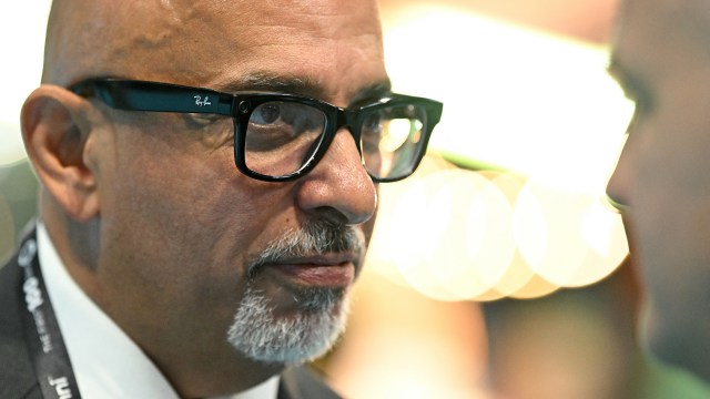 A close-up of a man wearing Ray-Ban Meta AI glasses and looking at someone nearby.