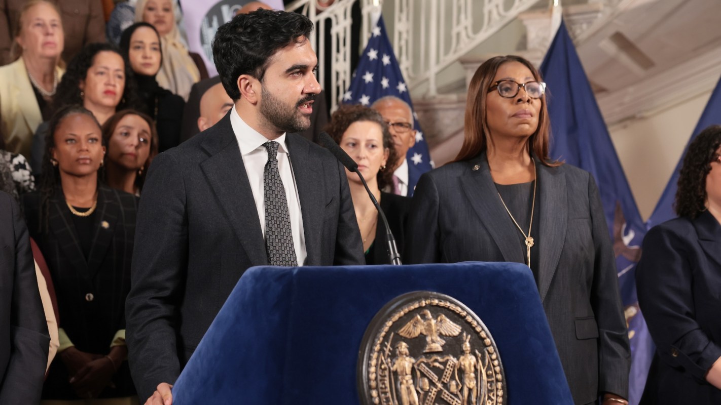 New York City Mayor Zohran Mamdani speaks at a podium in front of a group of people.