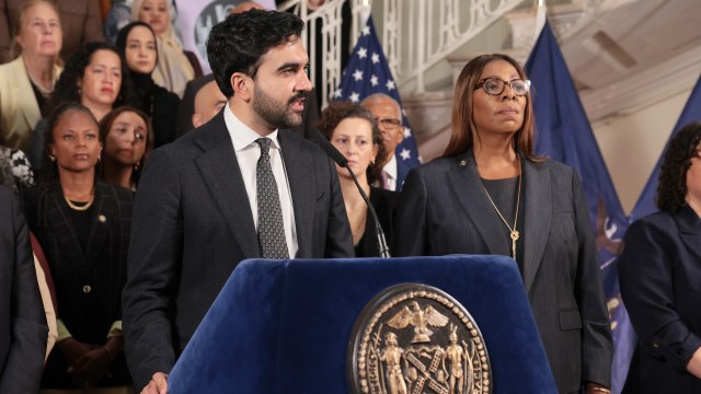 New York City Mayor Zohran Mamdani speaks at a podium in front of a group of people.