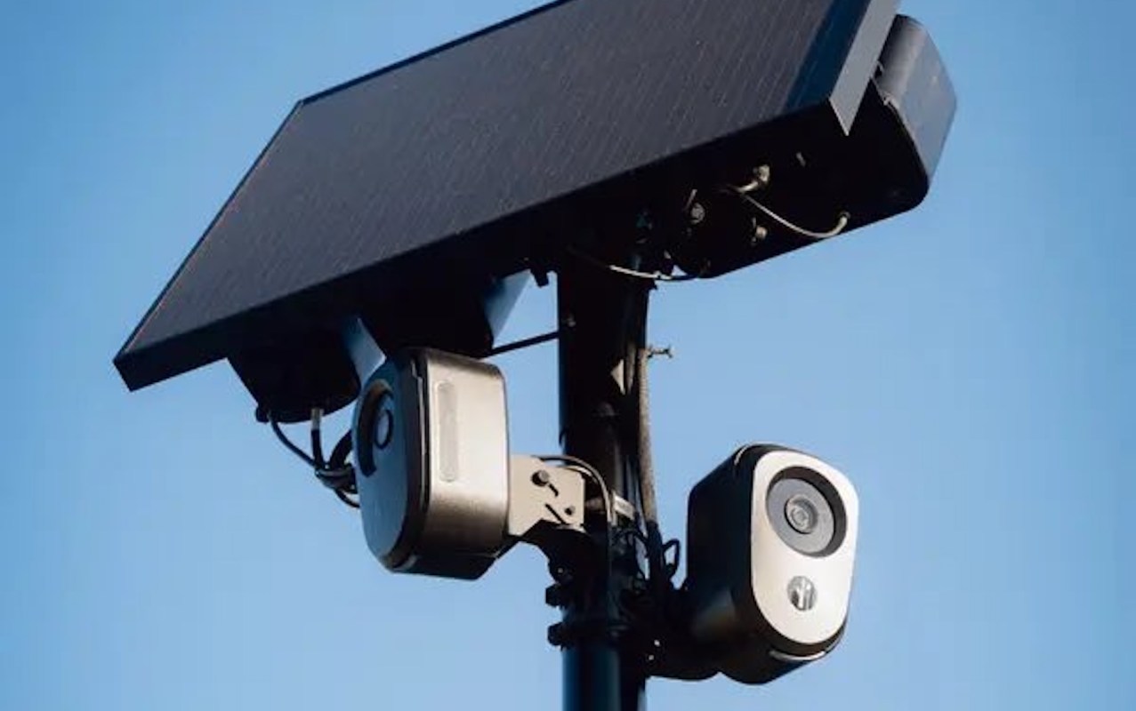 A Flock Safety camera on a pole with a solar panel at the top.