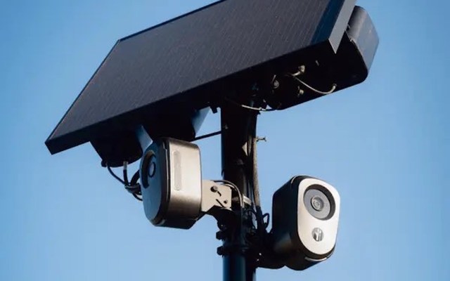 A Flock Safety camera on a pole with a solar panel at the top.