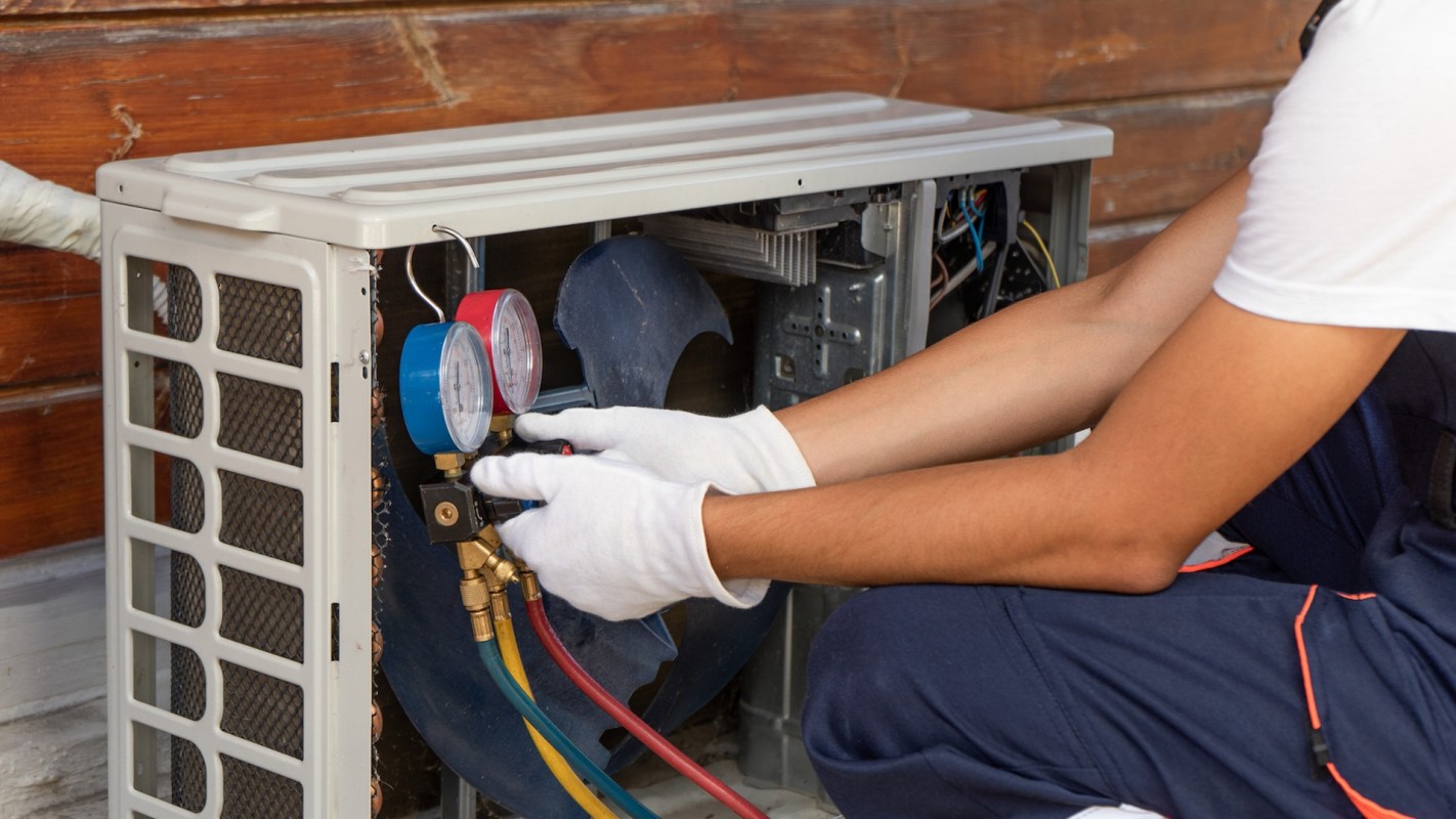 A technician works on an air conditioning unit.