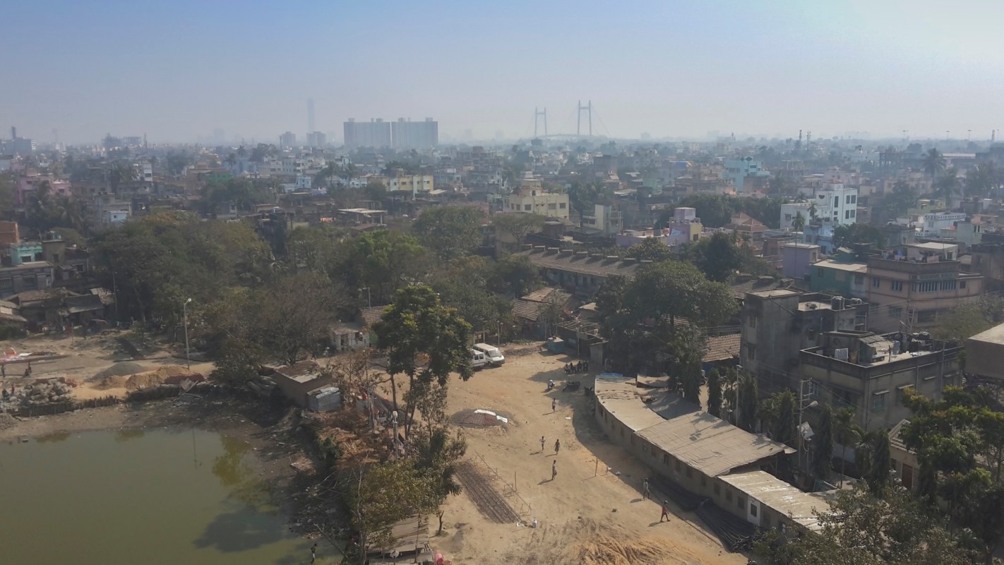 A view of a city with buildings, trees, and a bridge in the background.