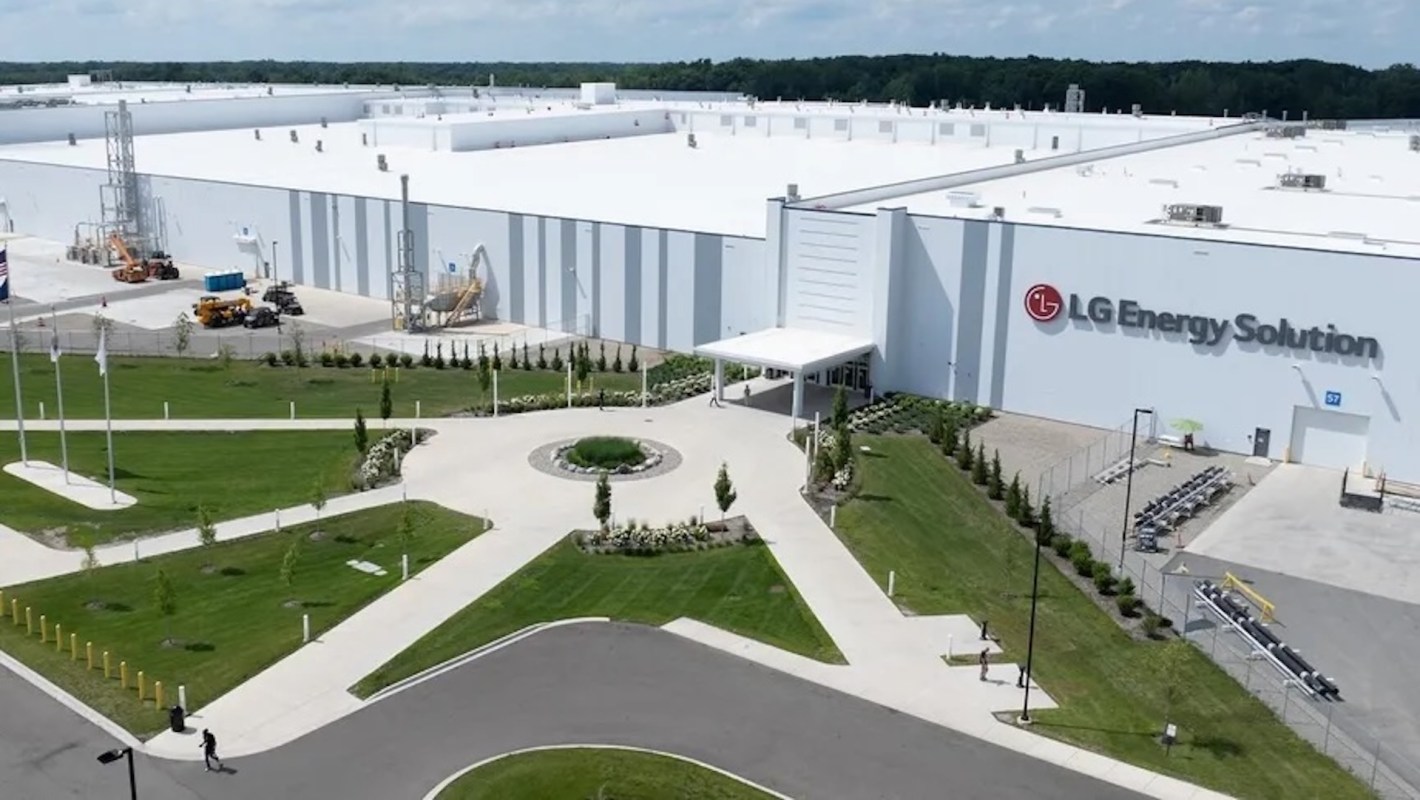 A large industrial building with the LG Energy Solution logo, surrounded by landscaped grounds and construction equipment.