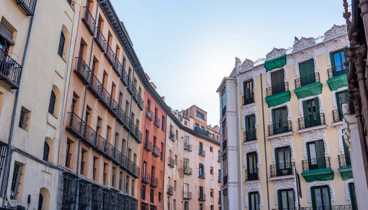 A series of colorful buildings with balconies in an urban setting under a clear sky.