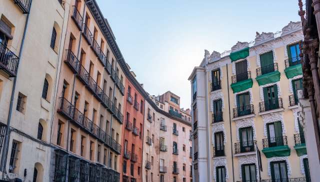 A series of colorful buildings with balconies in an urban setting under a clear sky.