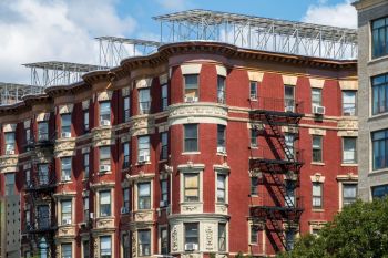 A red brick apartment building in New York has solar panels on the roof