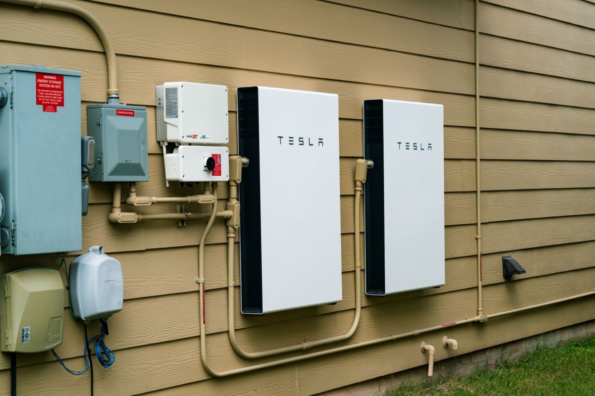 Two Tesla Powerwall units mounted on an exterior wall.