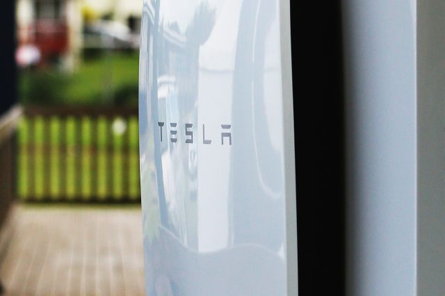 A Tesla Powerwall on the exterior of a house's porch