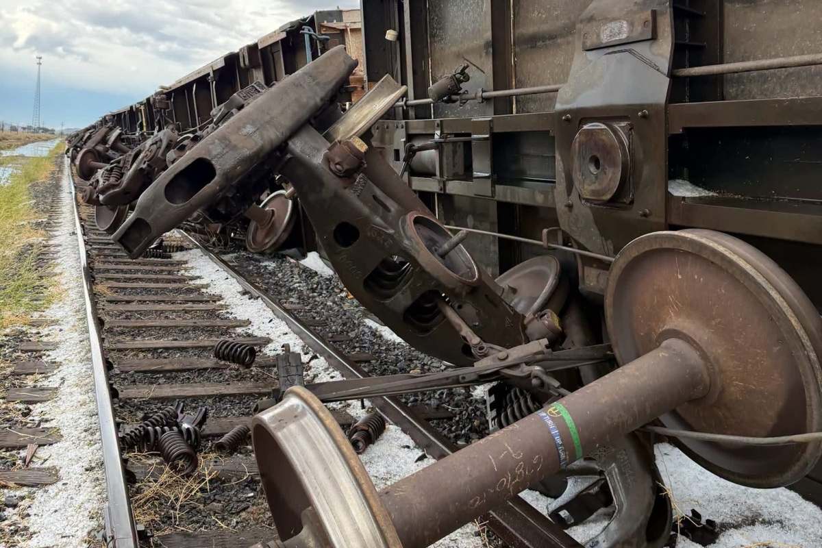 A derailed train car on the tracks, showing wheels and mechanical components.