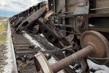 A derailed train car on the tracks, showing wheels and mechanical components.