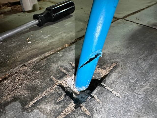 A blue pipe with a hole cut through it.