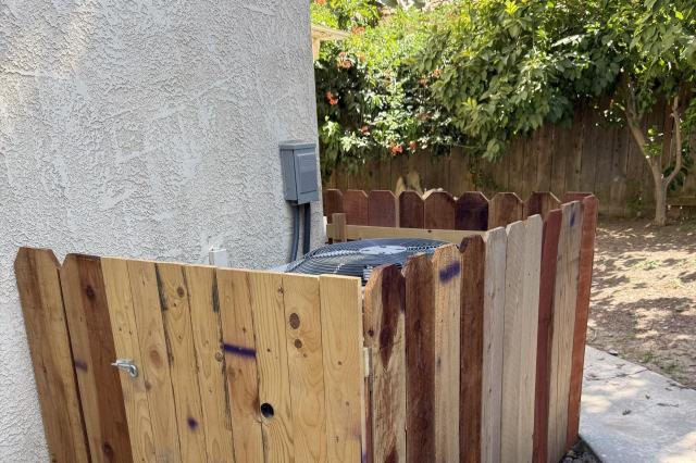 A fence around an outdoor AC unit.