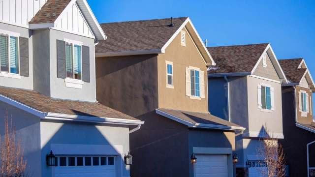 A row of modern houses with various exterior colors and architectural details.