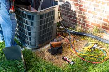 Technician working on an outdoor AC unit.