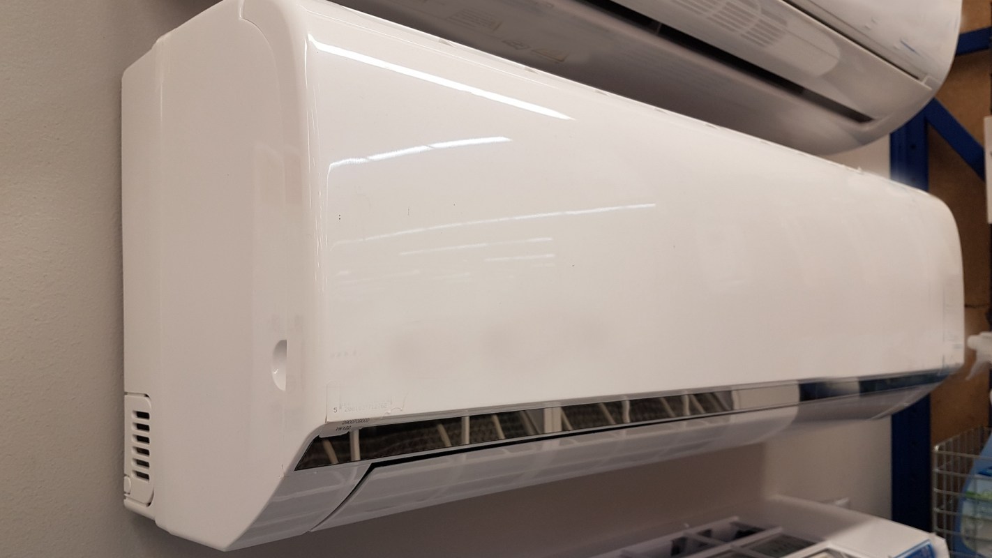 A white AC unit mounted on a wall.