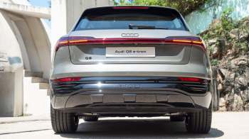 An Audi Q8 e-tron parked in an outdoor setting, showcasing its rear design and branding.