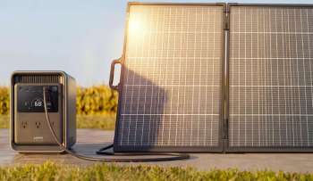 A portable solar generator connected to a solar panel on a sunny day.