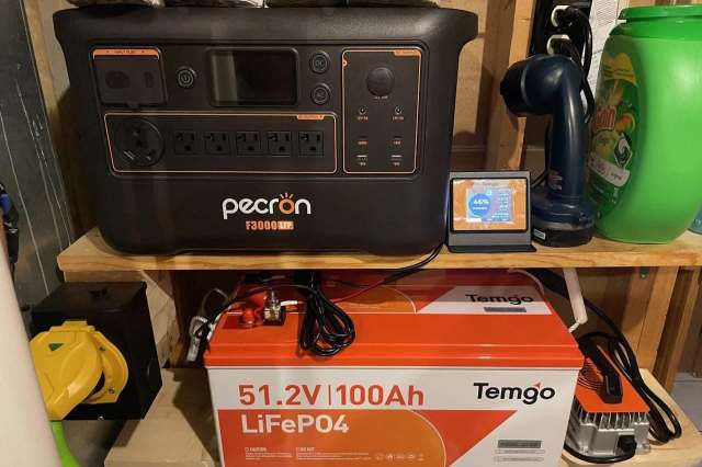 A power station and a battery displayed on a shelf alongside various household items.