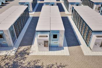 A grid of energy storage units arranged along a paved pathway.