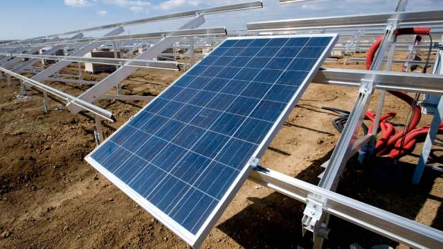 A solar panel installed on metal frames in a field.