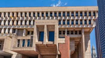 Boston City Hall building with a modern architectural design and blue sky in the background.