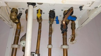 Pipes and valves connected to a water system under a sink.