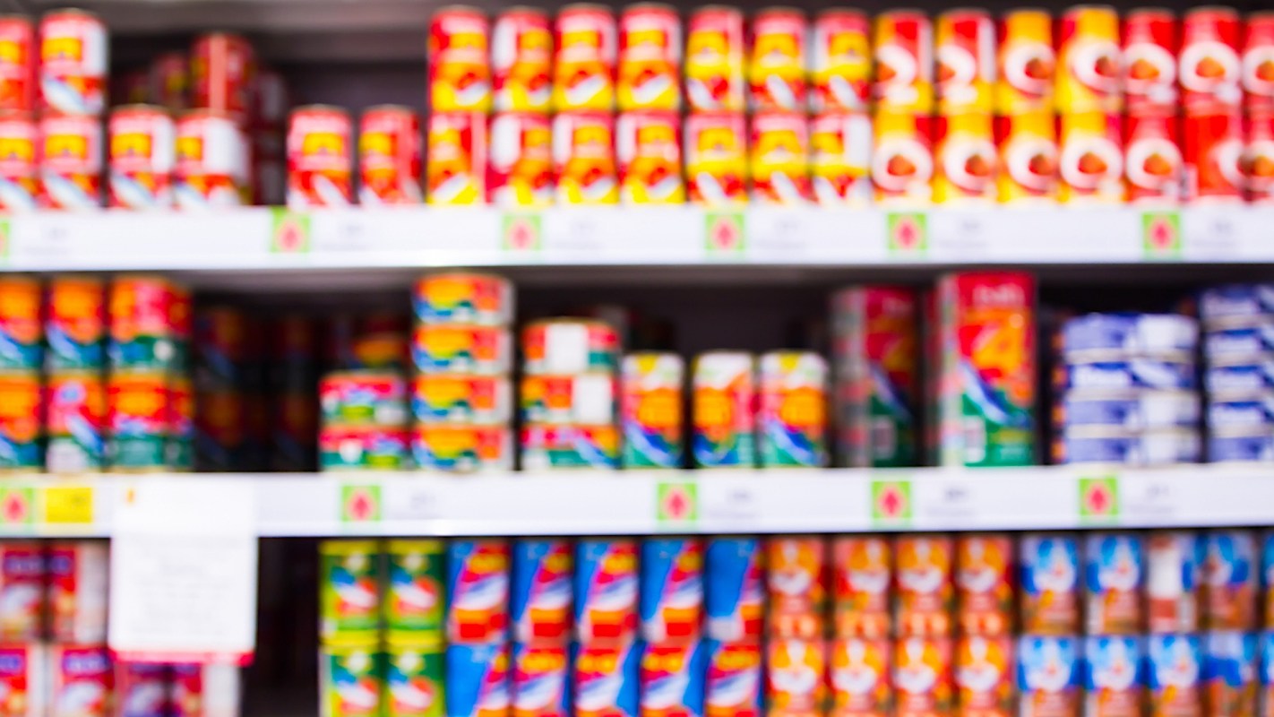 A blurred view of shelves filled with colorful canned products.