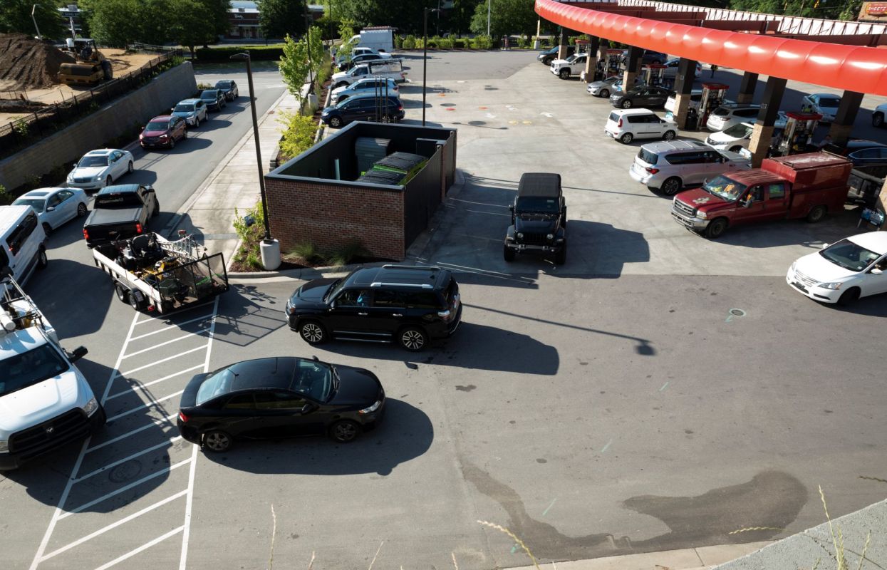 Cars lined up at a gas station.