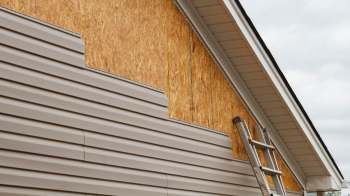 Vinyl siding being repaired on a house.
