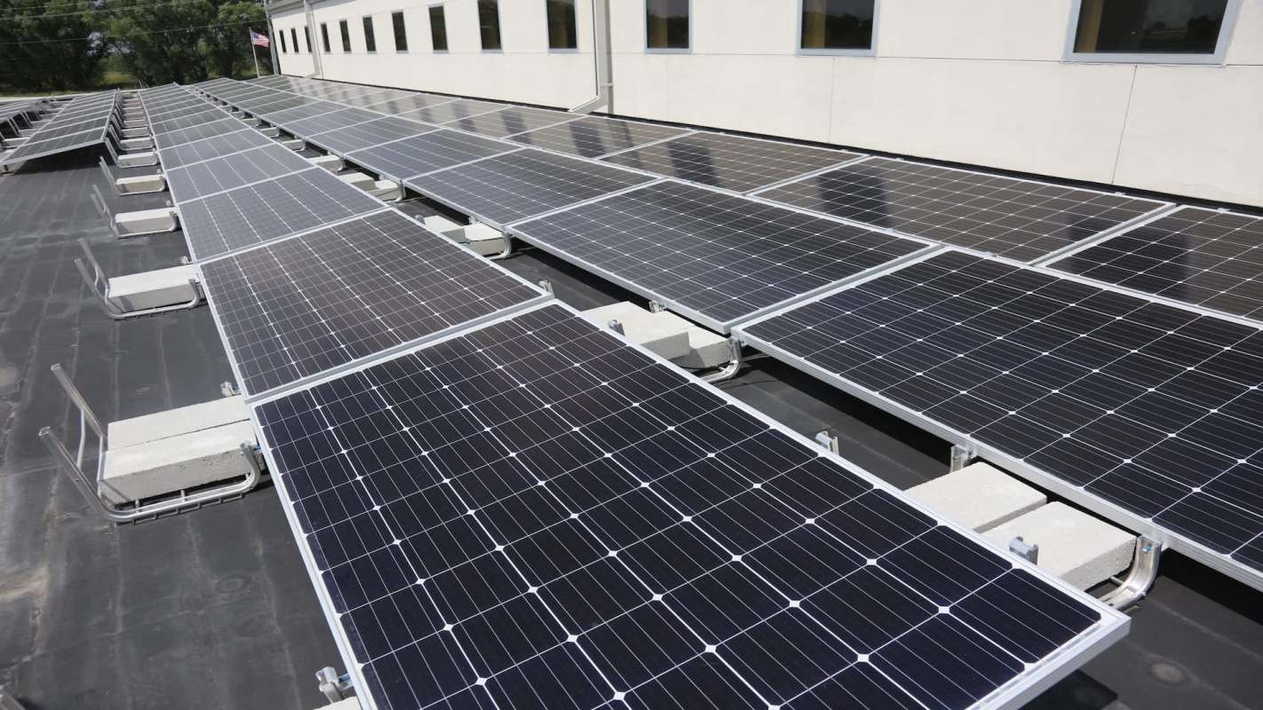 A flat roof covered with multiple solar panels.