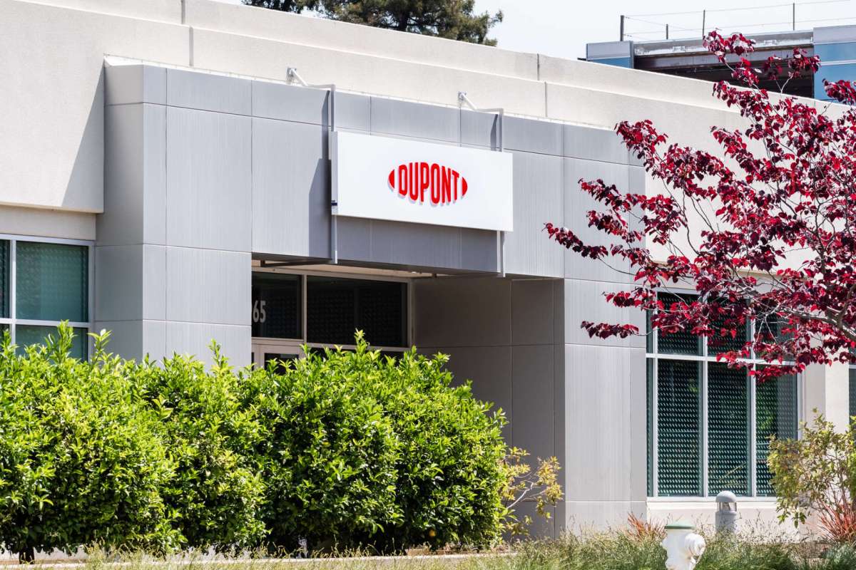 A building entrance featuring a sign that reads "DUPONT" and surrounding greenery.
