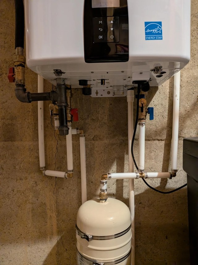 A close-up on the pipes connected to the water heater.