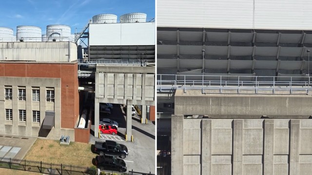 An industrial complex featuring large cooling towers and concrete structures with parked vehicles nearby.