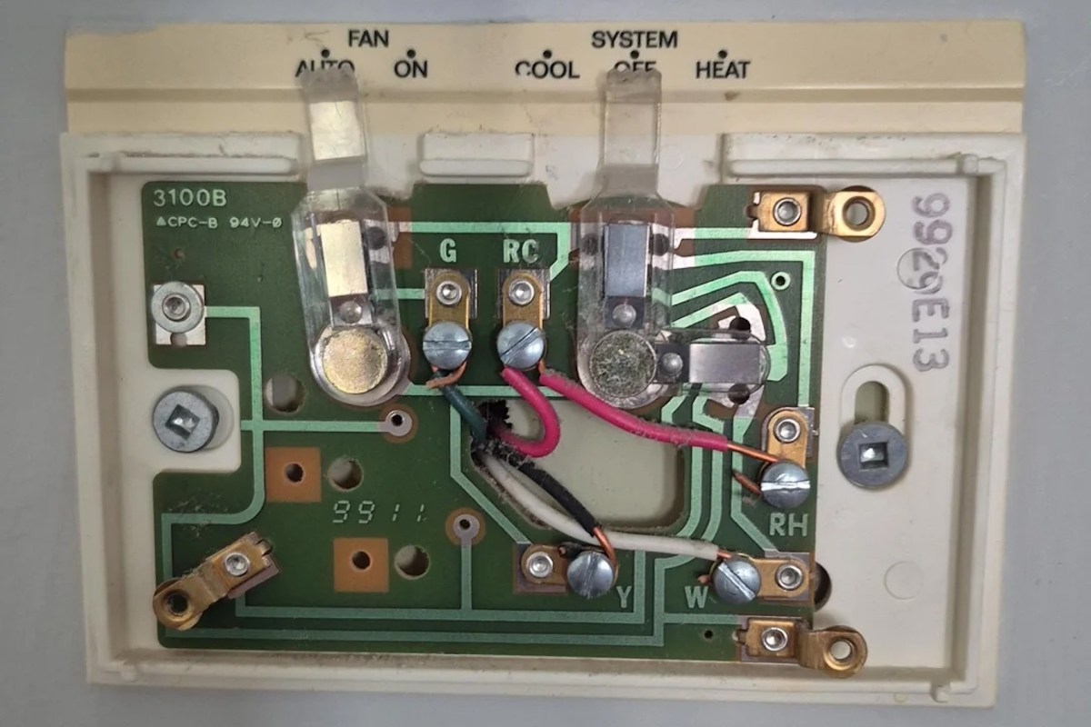 A circuit board from a thermostat showing various components and connections.