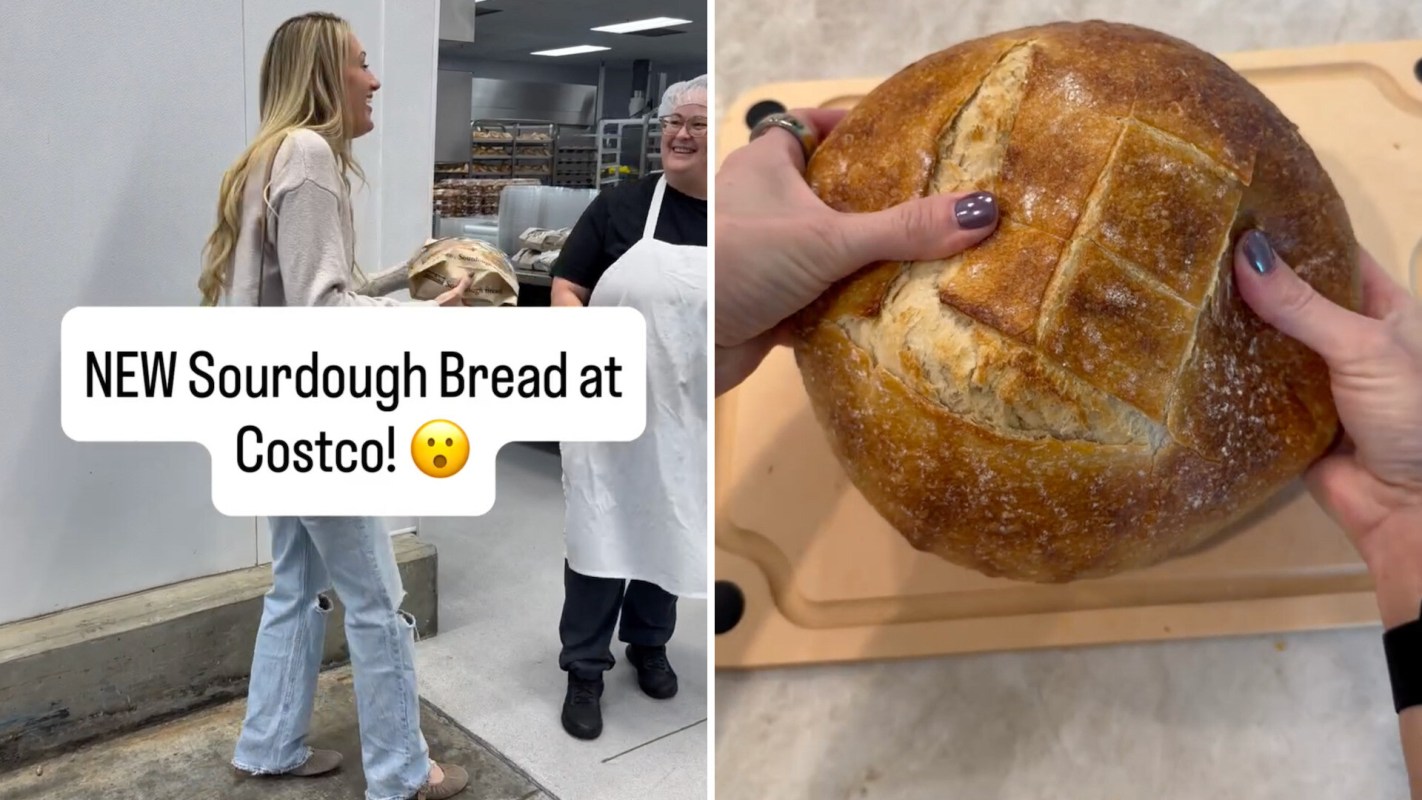 A woman holds a round loaf of sourdough bread in a store while another person smiles nearby.