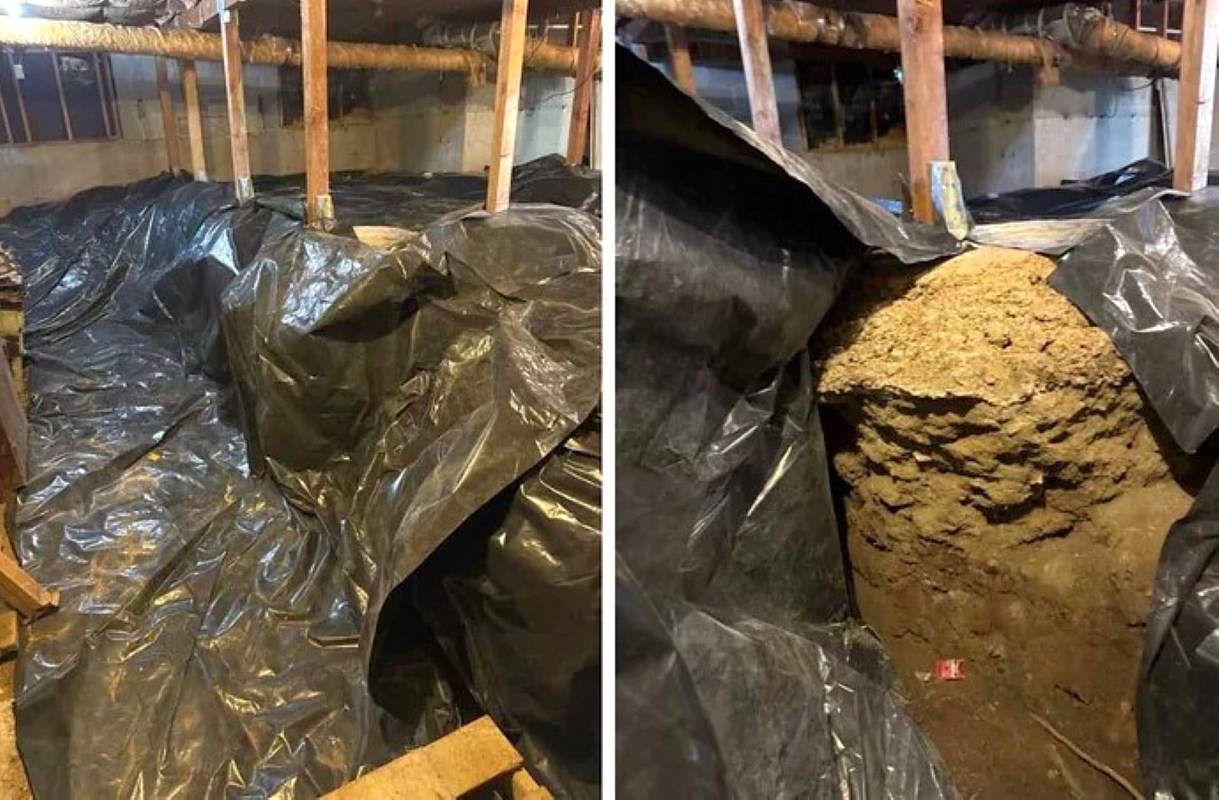 A basement area covered with black plastic sheeting and a pile of dirt visible underneath.