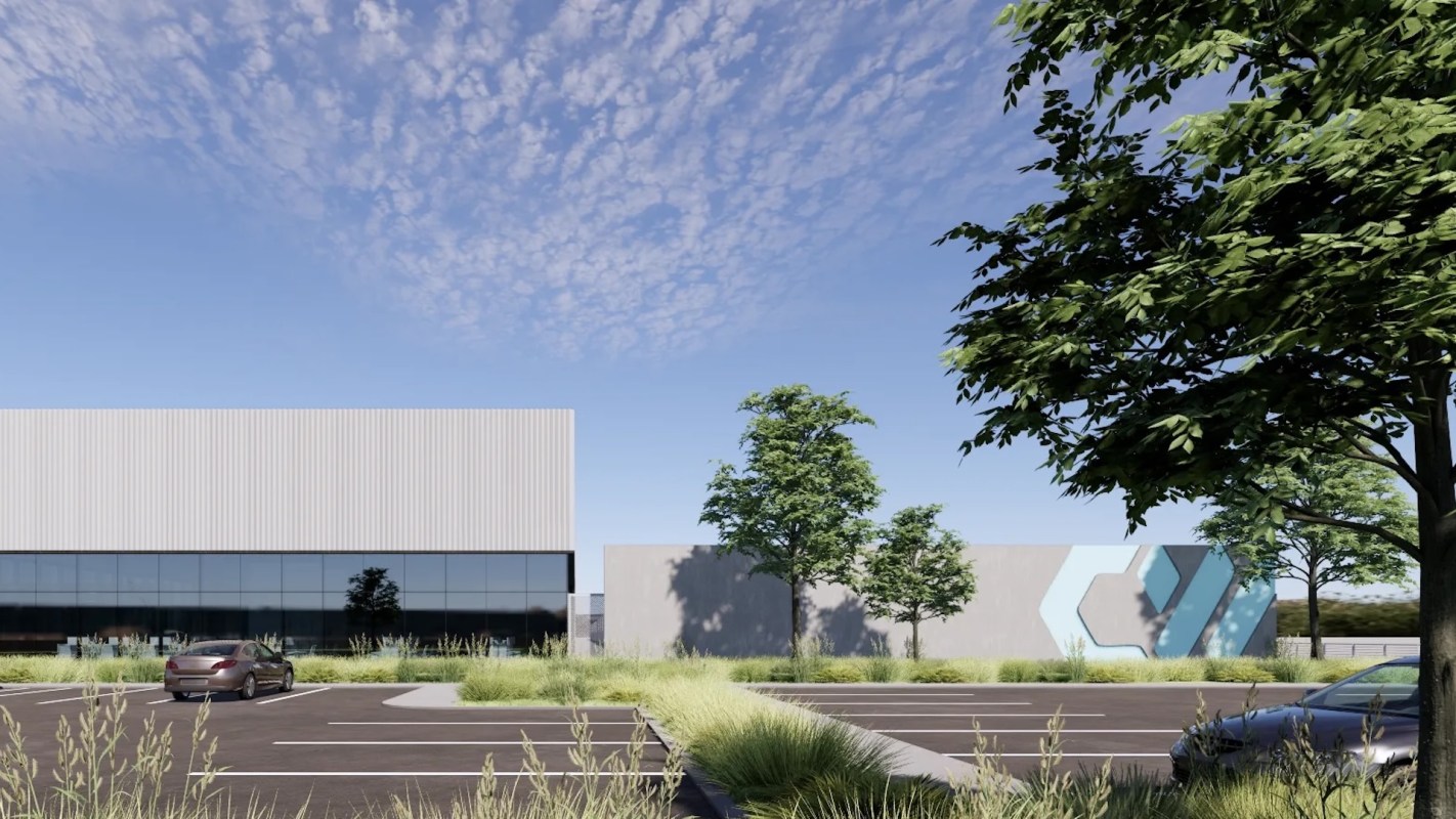 A data center with glass windows, surrounded by trees and a parking lot.