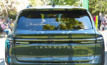 A black Leapmotor C10 SUV parked with reflections of trees visible on its rear window.