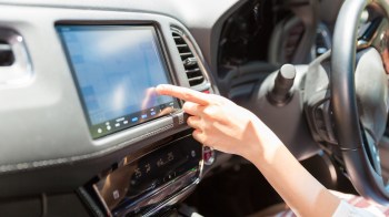 A person using a car's touchscreen.