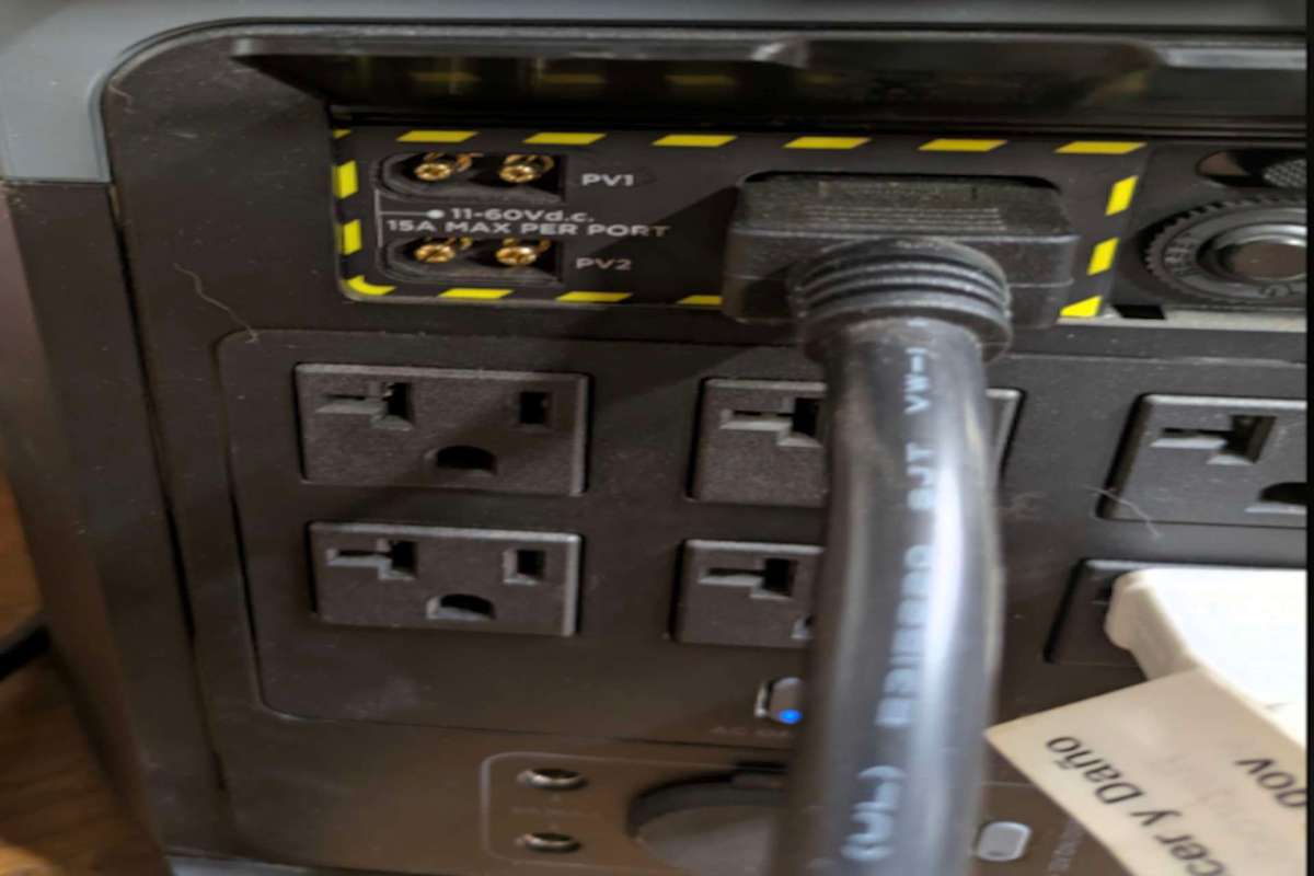 A power strip with multiple outlets and two yellow-labeled ports for connections.