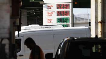 A gas station sign displaying fuel prices for regular and diesel fuel.
