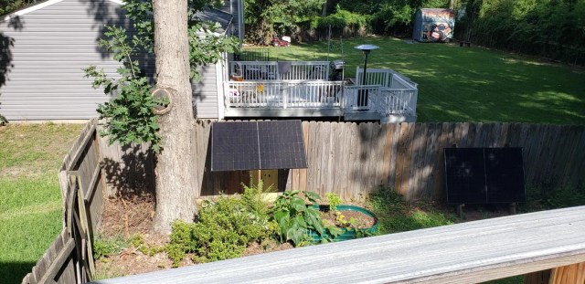 Solar panels mounted on a wooden fence.